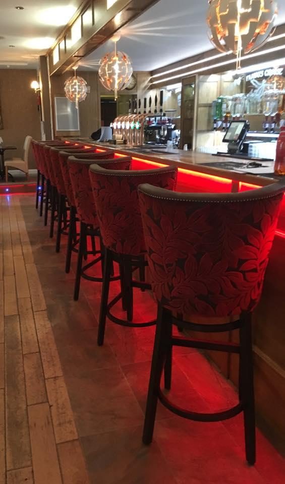 The bar, lined with red velvet stools
