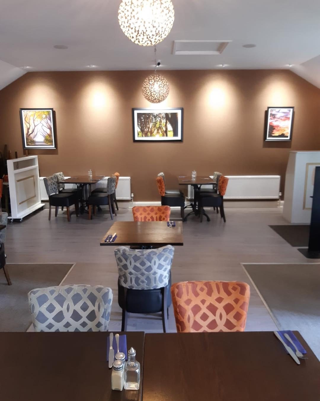 The restaurant dining room with patterned chairs and warm lighting