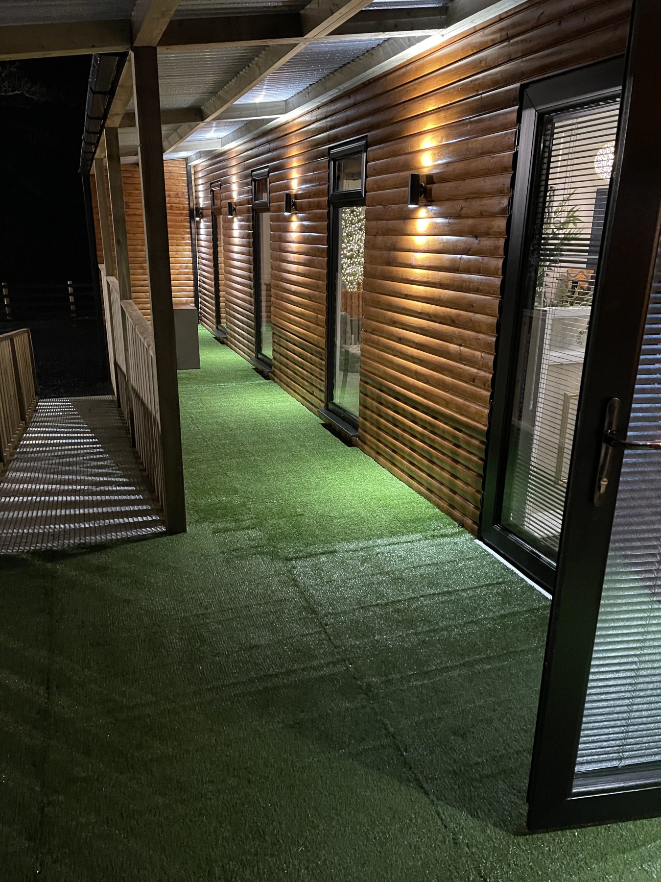 The new covered terrace with timber walls and wall lights